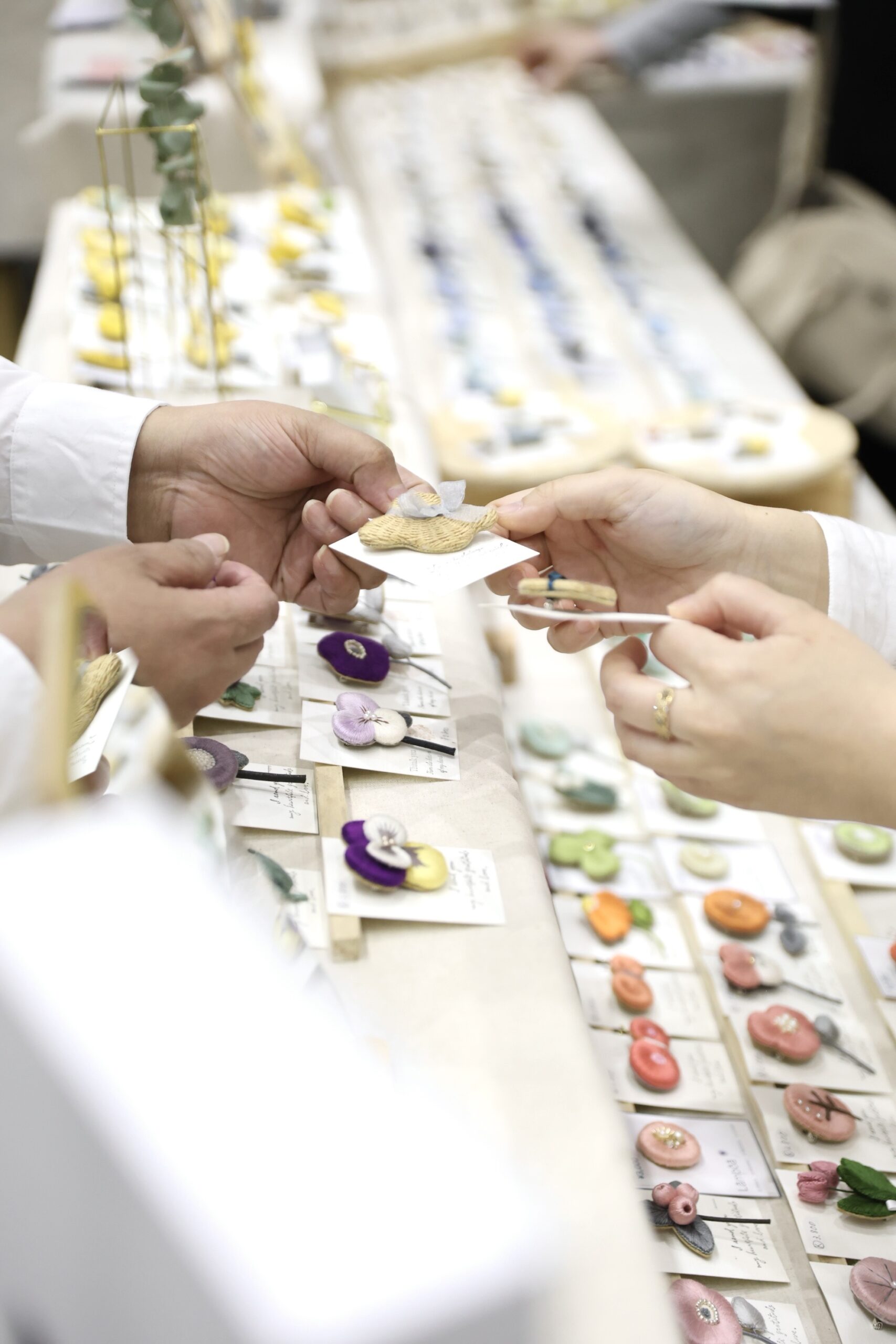マルシェでふっくら立体刺繍作品を手に取り選ぶ様子